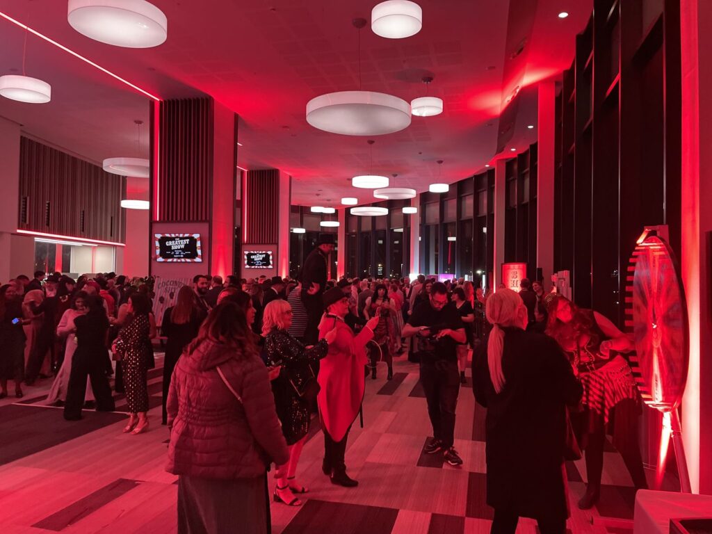 Conference delegates networking in a red-lit event space in Birmingham